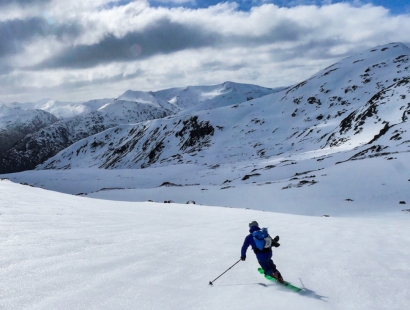 Someone ski touring on a sunny day on snow covered mountains in Scotland